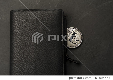 Close-up of a bitcoin coin lies on a black wallet 61803367