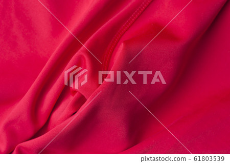 Fragment of crumpled red polyester fabric 61803539