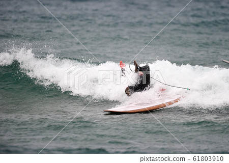 Surfers Enjoying Winter Surfing 61803910