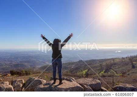 Girl woman reached the peak of the peak, admires the success, and the sun. Monchique, Foia, Portugal. Girl woman reached the peak of the peak, admires the success, and the sun. Monchique, Foia, Portugal. 61806807