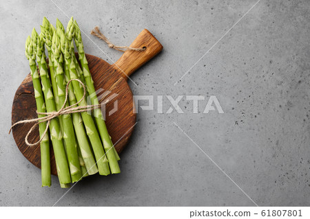 Bunch of green asparagus on concrete background Bunch of green asparagus on concrete background 61807801