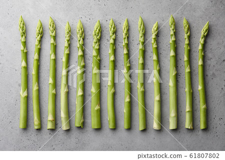 Fresh green asparagus on gray concrete background Fresh green asparagus on gray concrete background 61807802