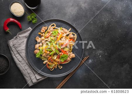 Udon with pork and vegetables on black background. Udon with pork and vegetables on black background. 61808623