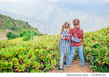 Beautiful happy little girls in mountains in the background of fog 61809191