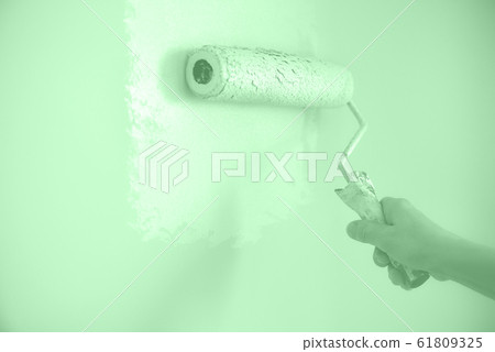 Hand painting wall with paint roller in trendy mint color. Appartment renovation, repair, building and home concept. Copy space, banner. Tools for painting walls. Hand painting wall with paint roller in trendy mint color. Appartment renovation, repair, building and home concept. Copy space, banner. Tools for painting walls. 61809325