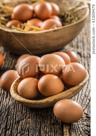 Fresh raw eggs in wooden bowl on rustic wooden Fresh raw eggs in wooden bowl on rustic wooden 61809479