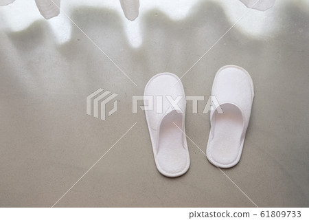 White slippers by white sheer curtains and soft sunlight, vacation concept 61809733