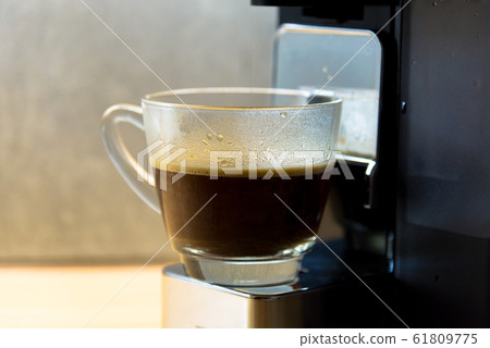 espresso machine with hot coffee in glass for refreshment 61809775