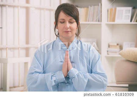 Woman doing qi gong tai chi exercise Woman doing qi gong tai chi exercise 61810309
