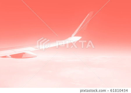 Travel concept. Wing of airplane flying above the clouds in trendy color sky. Mint green and turquoise color. Copy space 61810434