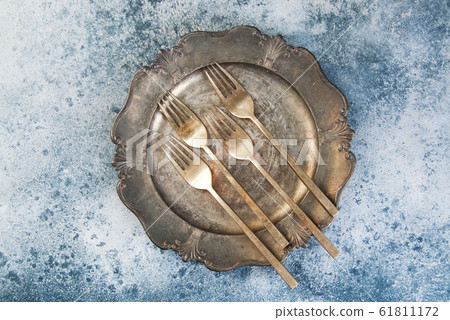 Old bronze forks on vintage dish 61811172