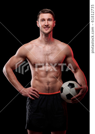 Happy muscular shirtless footballer with ball standing in front of camera 61812735