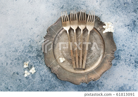 Old bronze forks on vintage dish Old bronze forks on vintage dish 61813091