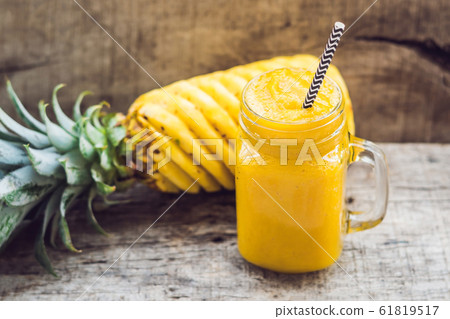 Pineapple smoothie with fresh pineapple on wooden table Pineapple smoothie with fresh pineapple on wooden table 61819517