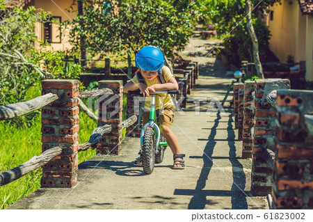 Little boy on a bicycle. Caught in motion, on a driveway motion blurred. Preschool child's first day on the bike. The joy of movement. Little athlete learns to keep balance while riding a bicycle 61823002