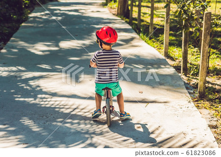 Little boy on a bicycle. Caught in motion, on a driveway motion blurred. Preschool child's first day on the bike. The joy of movement. Little athlete learns to keep balance while riding a bicycle 61823086