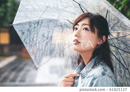 一個戴著雨傘的女人雨門前的啞光飾面b-2 61825137