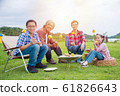 Group of asian family grilling sweet corn on stove at camping site. 61826643