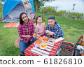 Asian family preparing barbecue for dinner at camping site 61826810