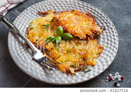 Fried cakes of grated potatoes on the plate with 61827518