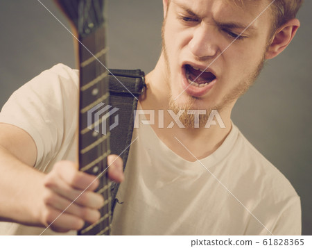 Man playing on electric guitar 61828365