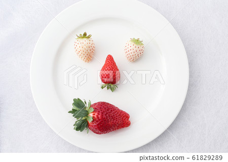 Face drawn with strawberries arranged on a plate 61829289