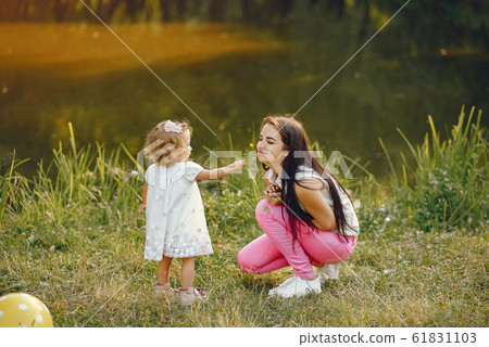 Mother with daughter playing in a summer park Mother with daughter playing in a summer park 61831103