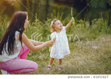 Mother with daughter playing in a summer park 61831827