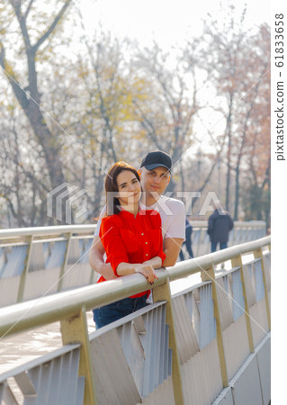 Happy young lovers stand on the iron bridge in 61833658