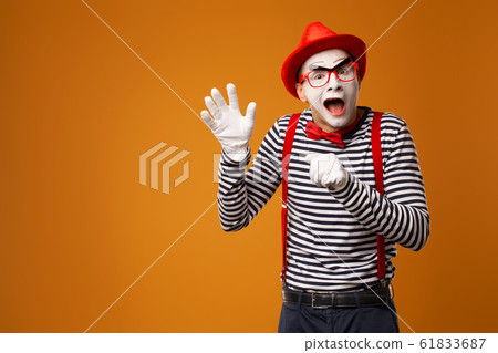 Happy mime man in red hat, white gloves and striped t-shirt on blank orange background 61833687