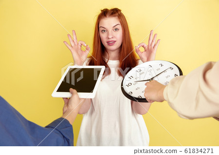 Caucasian young woman's portrait on yellow background, too much tasks 61834271