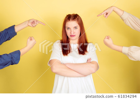 Caucasian young woman's portrait on yellow background, too much tasks 61834294