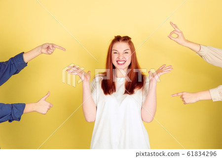 Caucasian young woman's portrait on yellow background, too much tasks 61834296