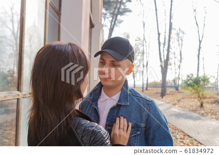 Happy lovers by the window in the park in autumn Happy lovers by the window in the park in autumn 61834972