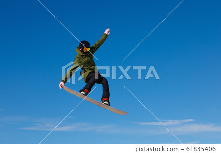 Snowboarder jumping high in the air Snowboarder jumping high in the air 61835406