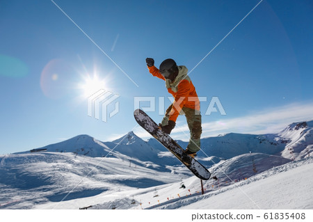 Snowboarder does the jumping trick Snowboarder does the jumping trick 61835408