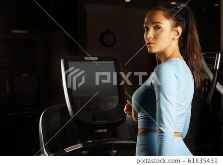 Young attractive woman running on a treadmill 61835431