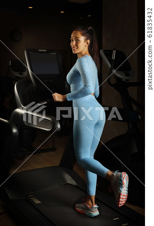 Young pretty woman running on a treadmill 61835432