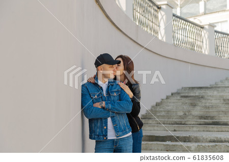 Happy lovers hug on a concrete staircase. 61835608