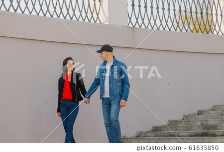 Loving couple walk up the concrete stairs and hold 61835850