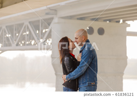 Happy lovers stand under the bridge on a sunny day 61836121