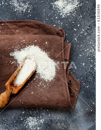Coconut flour in a wooden spoon close up 61836846