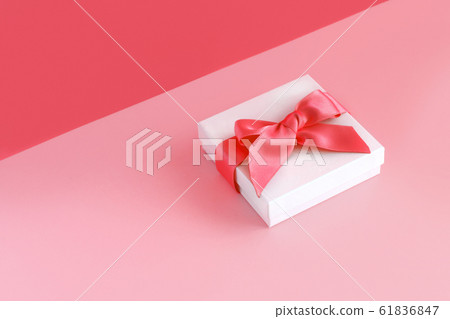 White gift box with a bow on a light pink 61836847
