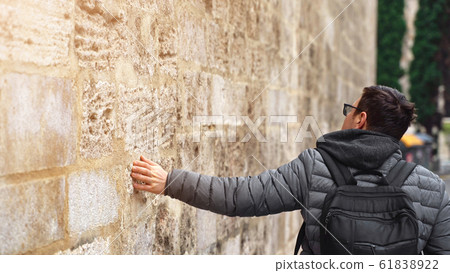 Man hand stroke surface, slide on stony wall of old building at Gothic Quarter of Barcelona, travel 61838922