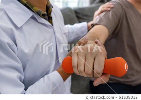 Physiotherapist working with patient doing with 61839012