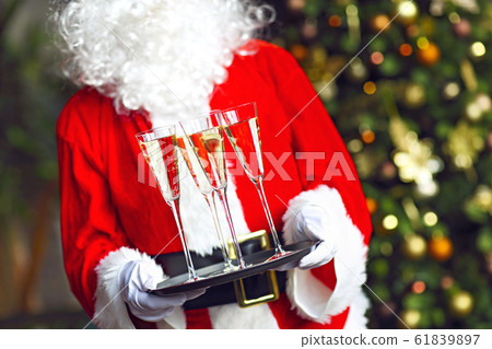 Santa Claus holding champagne glasses on the tray Santa Claus holding champagne glasses on the tray 61839897