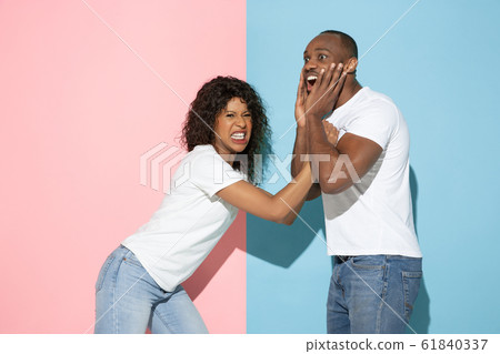 Young emotional man and woman on pink and blue background 61840337