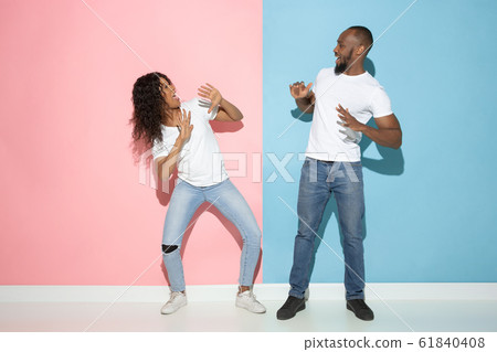 Young emotional man and woman on pink and blue background Young emotional man and woman on pink and blue background 61840408