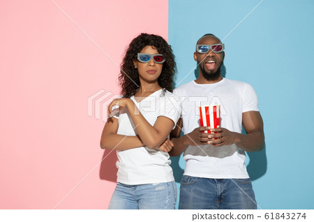 Young emotional man and woman on pink and blue background 61843274