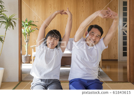 Mature couple doing yoga stretching at home Mature couple doing yoga stretching at home 61843615